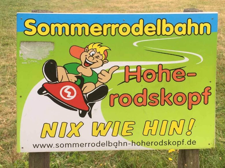 Schild der Sommerrodelbahn Hoherodskopf – „Nix wie hin!“